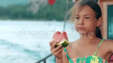 海上航行时吃西瓜的漂亮女孩。 小女孩吃西瓜