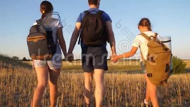 旅<strong>途中</strong>的游客家属。 爸爸带着两个女儿去野营旅行。 带背包的孩子和父亲正在散步