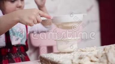 小可爱的女孩在厨房用过滤器过滤面粉