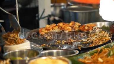 厨师在夜间<strong>食品</strong>市场上用面条和<strong>海鲜</strong>烹饪泰国菜。 美味的亚洲街头美食，关门