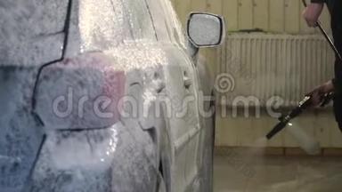 <strong>洗车</strong>机清洗汽车。 <strong>洗车</strong>工人在汽车上涂上泡沫。 特写镜头。