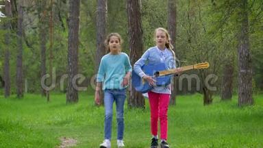 春天<strong>漫步</strong>在城市<strong>公园</strong>里两个带着吉他的白人小女孩在森林小径上玩耍
