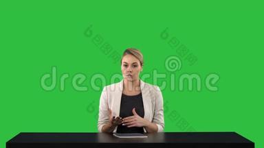 电视女主播在演播室指向侧面的绿色屏幕，Chroma键。