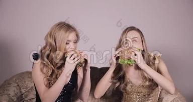 两个女朋友在<strong>吃汉堡</strong>包。两个女人<strong>吃</strong>着美味的<strong>汉堡</strong>