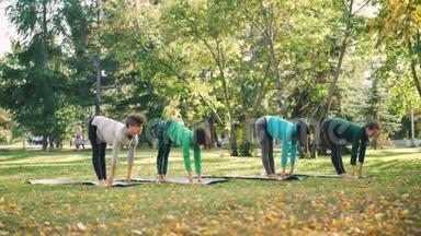 灵活的年轻女士在秋日公园里做瑜伽练习，然后在<strong>垫子</strong>上放松和呼吸