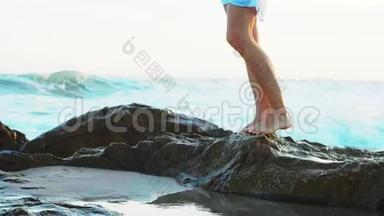 女人走在沙滩上，有大石头，腿特写。