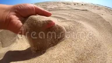 慢动作。 女孩拿起一把沙子在她的手掌和洒