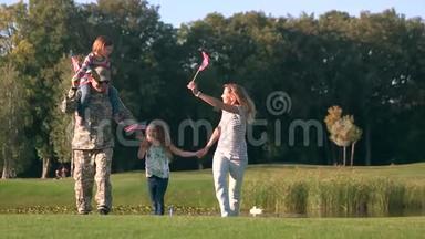 来自美国的家人在公园前景色中挥手背景。