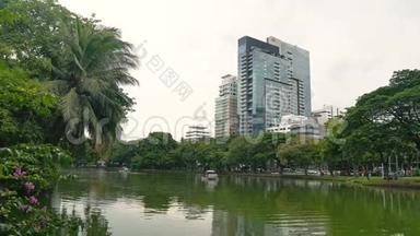 城市公园附近的办公楼.. 摩天大楼和自然：湖面和绿树对高楼