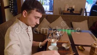 茶师在仪式上用热水暖茶碗和公平水壶