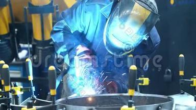 戴面具的工人用手工夹子固定金属坯料的焊接