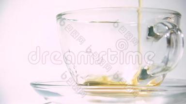 在白色背景特写镜头上，将茶壶中的红茶香气注入一个匹配的透明<strong>玻璃茶杯</strong>。