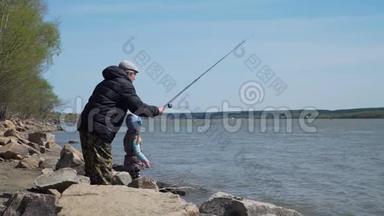 小女孩和她的爷爷在河边钓鱼