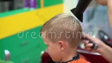 一个小男孩在儿童美发沙龙`理发