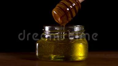 特写美味的蜂蜜滴从蜂蜜勺在一个罐子美味的镜头