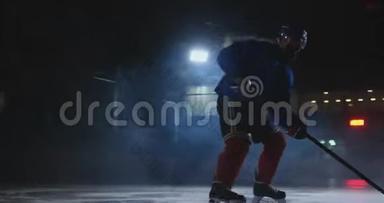 一个曲棍球<strong>运动</strong>员，手里拿着一根棍子，从黑暗中走出来，把<strong>冰球</strong>放在冰上