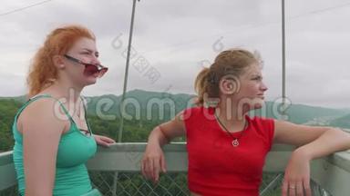 红发白种人和金发白种人女人看着从高山上的吊桥<strong>蹦极</strong>。 全景