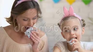 可爱的女儿和母亲一起吃巧克力蛋，享受消遣，家人
