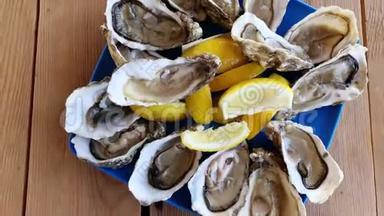 新鲜牡蛎在蓝色盘子上特写，提供牡蛎、柠檬和冰的桌子。 桌面视图。 健康的海洋食物。 新鲜<strong>生蚝</strong>