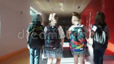 回学校去。 后景。 学生穿过学校走廊。 两个男孩和两个女孩。 孩子们背背包
