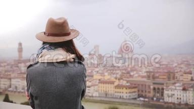 <strong>喜笑颜开</strong>的旅游女孩，穿着温暖的衣服，欣赏意大利佛罗伦萨令人惊叹的全景，在雨天走开