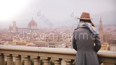 戴帽子的女孩站在<strong>观景台</strong>欣赏意大利佛罗伦萨的美景，在寒冷的阴雨天。