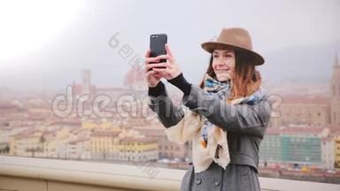 快乐女游客在令人难以置信的意大利秋<strong>季</strong>佛罗伦萨全景拍摄智能<strong>手机</strong>自拍照片，欣赏风景。