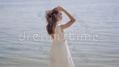 肖像迷人的年轻女孩，留着长长的黑发，穿着一件白色的<strong>夏季</strong>时装<strong>长裙</strong>，站在河边
