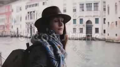 美丽放松的欧洲旅游女孩看着相机，微笑着在秋天的威尼斯奇妙的贡多拉游览。