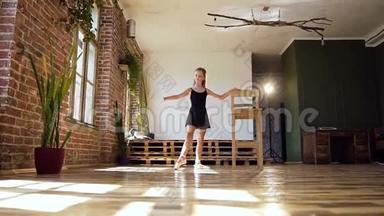 年轻迷人的芭蕾舞演员穿着黑色西装在舞蹈室的皮鲁埃特练习。 美丽苗条的女孩跳舞