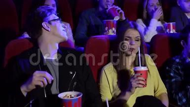 在电影院里坐在红色椅子上看电影的青少年特写。