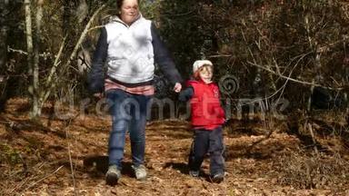 一个女人和一个孩子从森林里的狗<strong>身边</strong>跑开了。