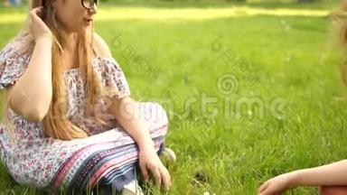 两个十几岁的女朋友在公园里坐在草地上下棋。 学校假期，青少年智力游戏
