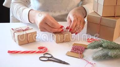 圣诞礼物装饰。 手工装饰概念。 女人在白色的桌子上包装礼盒。