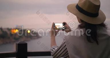 穿着休闲服装、用智能手机拍照城市港湾的千禧女游客