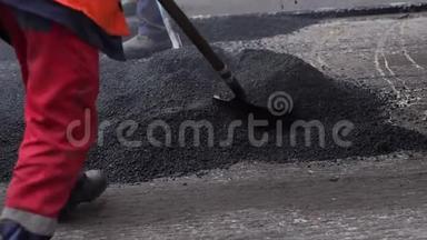 工人在修路铺上沥青. 修复道路。 沥青。