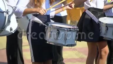 街头表演的鼓手男孩的节日游行服装在城市街头。 女孩手鼓的特写镜头