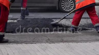 工人在修路铺上沥青. 修复道路。 沥青。