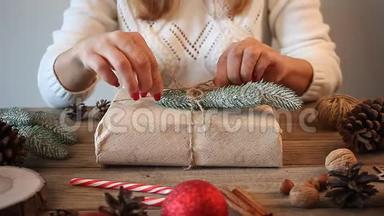 圣诞礼物装饰。 手工装饰概念。 女人在木桌上包装礼盒。