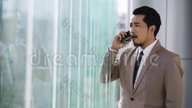 穿着<strong>讲究</strong>的商人在办公室用手机说话
