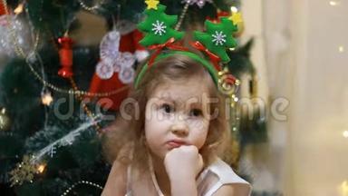 悲伤的女孩期待圣诞老人和圣诞礼物。 新年和圣诞树