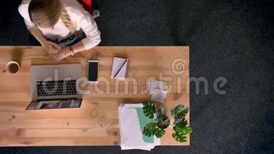 多利在办公室里用笔记本电脑拍摄了一个穿着随意的女人在电玩聊天。