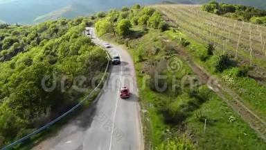 一辆红色复古汽车在蛇形公路上的俯视图。