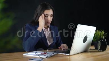 坐在电脑前的自由职业者女孩，厌倦了工作，头痛。那个商人工作<strong>很累</strong>。