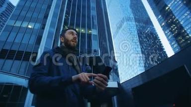 <strong>商业综合体</strong>，一个男人在旁边操作他的智能手机。