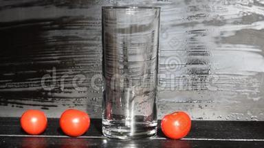 <strong>蕃茄</strong>汁流入黑暗背景下的玻璃杯