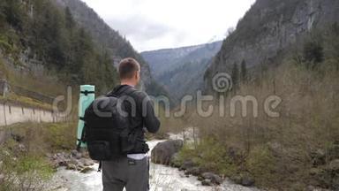 男子旅游徒步旅行者带背包，欣赏风景秀丽的山河景观。 旅行徒步旅行者<strong>远离</strong>。 旅行，人们