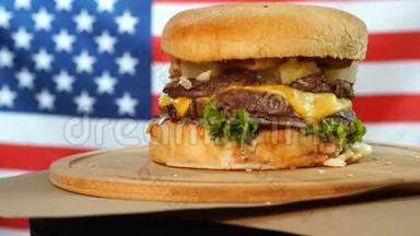 烤美国<strong>牛</strong>肉汉堡，配生菜、奶酪、洋葱，放在木制柜台上旋<strong>转</strong>的棕色纸上。
