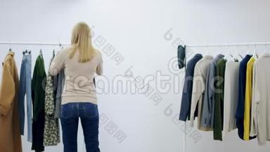 成年妇女在更衣室里摆着一件外套和一件皮夹克