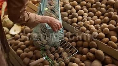女人把手放在一个串袋里，从市场上的木箱里拿出新土豆。 环保包装，零废物